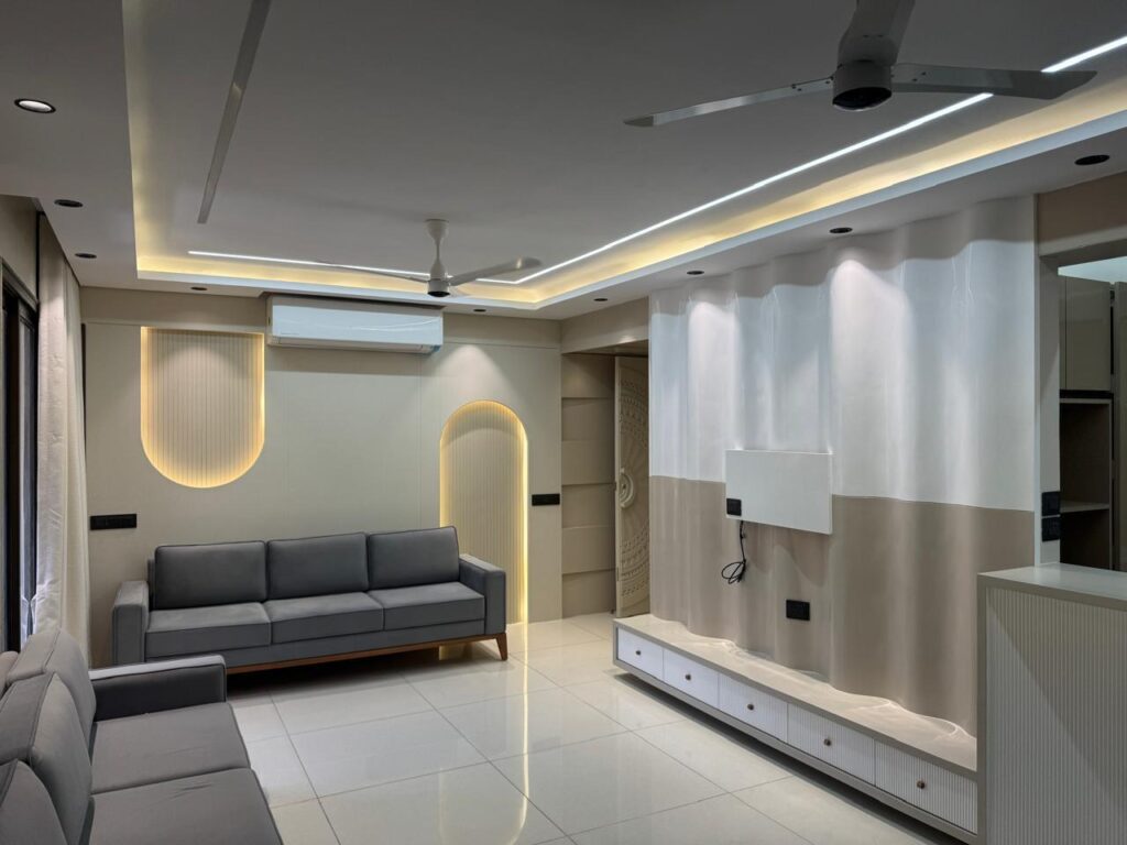 Modern living room interior design in Ahmedabad Modern living room interior design in Ahmedabad with LED ceiling lights and grey sofa