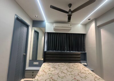 Bedroom interior with upholstered headboard, POP ceiling with panel lights, and compact layout