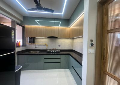 Modern modular kitchen with overhead cabinets, quartz countertop, and integrated ceiling lighting