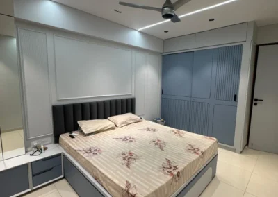 Bedroom interior with storage bed, side tables, and clean ceiling lighting in a modern layout