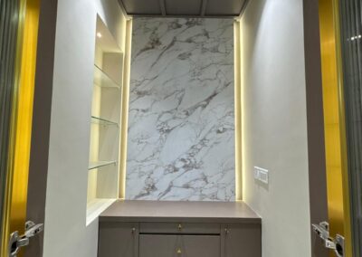 Decorative niche with marble-finish panel, open shelves, and warm backlighting