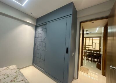 Sliding wardrobe with laminate finish, CNC cut detailing, and clean modern design designed by J Designs