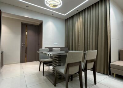 Dining area with six-seater table, upholstered chairs, curtains, and POP ceiling lighting