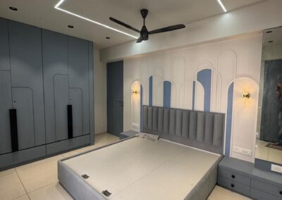 Modern bedroom interior with accent wall arches, low platform bed, and geometric ceiling lighting by J Designs