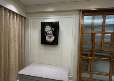 Minimal bedroom interior with low bed, wooden window frame design, curtains, and soft ceiling lighting by J Designs